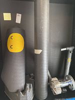 Photo showing two black exercise mats and a CycleOps fluid trainer block with a yellow smiley face on one mat.
