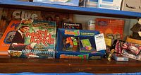 Shelf showing board games including Match Game DVD Edition, Clue, Perquackey, and Square-1 puzzle, plus small toys and collectibles including yo-yos and a boxed Energizer Bunny toy.