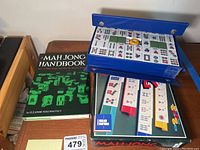 Photo showing Mahjong handbook and one Mahjong set case slightly open with tiles laid on top