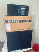KLH-100 radio and pair of Paradigm KLH-100 model speakers with the original KLH cardboard box underneath.