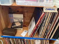 Shelf view showing classical vinyl LPs, wooden Discwasher box, DiscFoot box, Zerostat box and a loose record sleeve