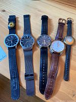 All five watches lined up on wooden surface