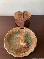 Top view of the small wooden heart-shaped box and round ceramic plate with deer and forest scene