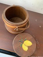 Open view of the vintage wooden bucket with lemon painted on lid, showing interior and detached lid.