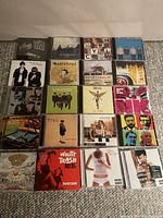 Photo showing all 20 CDs arranged in 5 rows of 4, including notable albums by bands such as Weezer, Nirvana, Train, and U2 among others.