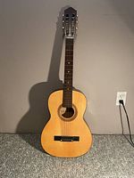 Full view of the Anjo acoustical guitar showing its standard classical body shape, fretboard, tuning pegs, and natural wood finish.