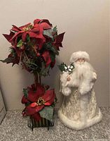 Santa figurine and poinsettia topiary on table, showing size and design