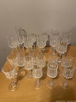 Front view of the arranged assortment of 25 crystal glasses with detailed faceted cuts