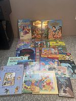 Photo showing an array of Disney children's books arranged on the floor featuring multiple titles and characters