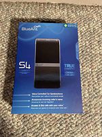 Front view of the new BlueAnt S4 Bluetooth car speakerphone box on carpet