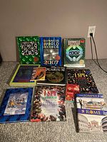 Photo of ten hardcover books including multiple editions of Guinness World Records, Ripley's Believe It or Not!, and other educational and reference books.