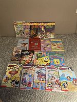 Photo showing entire collection of 16 children's books including Geronimo Stilton novels, Spongebob Squarepants, Powerpuff Girls comics, and other kids titles