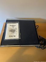 Top view of Mastercraft wet tile saw showing black ribbed cutting surface and power cord coiled beside it.