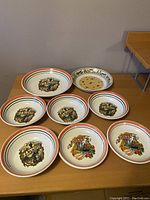 Set of eight ceramic pasta dishes arranged on a table, displaying various Italian-themed designs and rim colors