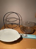 View of serving rack, ceramic dish, glass lid dish, and boxed Oneida serving set