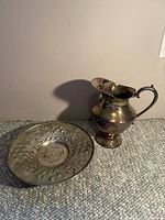 Plate and pitcher together showing tarnish and general condition.