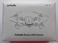 The product box front displaying a black and white illustration of the foldable drone including the brand name 'Zuhafa', recommended age 14+, and product features.