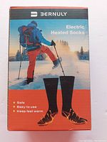 Front packaging of Bernuly Electric Heated Socks showing winter hiking scene, product image, and benefits.