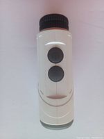 Front view showing two buttons labeled Power and Zoom on white handheld laser rangefinder.