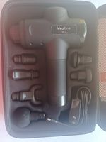 Wattne W2 massage gun with six attachment heads and charger inside the carrying case.