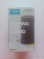 Front view of product box showing Soundcore Flare Mini speaker image and features including Bluetooth, IPX7 waterproof rating, and 12-hour playtime.