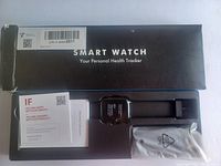 Box packaging and contents of smart watch set: black smart watch with display and strap, user manual, and charging cable.