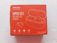Front of orange MPOW M13 earbuds box showing illustration of earbuds and charging case.