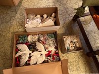 Photo of boxed vintage nativity set and other Christmas decorations including birds and cherubs, displayed on a vintage patterned floor.
