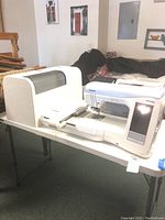 Machine on fold-out table with extension table and hoop unit attached