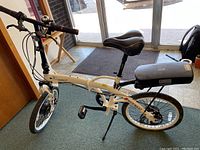Overall 3/4 view of white folding e-bike showing frame, saddle, battery pack and handlebar.