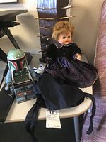 Star Wars Boba Fett alarm clock and Madame Alexander doll with an additional outfit on a small table.