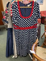 Group photo of three women's dresses including navy polka dot, floral and grey dresses