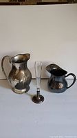 Three items including the Birks sterling vase with tall clear glass body and two tarnished silverplate pitchers