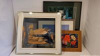 Four framed wall art pieces shown together featuring wood duck art, floral painting, iceberg photo, and pitcher with flowers painting.