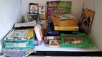 Various craft supplies, Pink Panther comics, ribbons, felt, tea towels, and other crafting materials laid out on a white surface under natural light.
