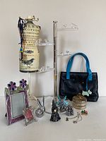 Overview of metal figurines, photo frames, jewelry stands, Radley handbag, metal bunny, trinket container, and cat-themed jewelry
