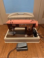 Full view of vintage Brother Charger 651 sewing machine with foot pedal and carrying case on floor.