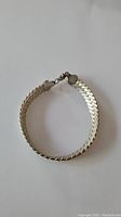 Silver 925 stamped bracelet formed in a circle, showing clasp and end caps.