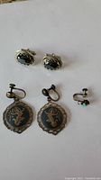 Photo of cufflinks and earrings arranged on white background showing front and back sides