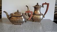 Silverplate coffee pot and teapot set photographed together on counter, showing overall patina and style
