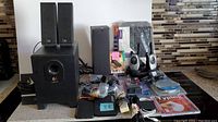 Full overview of the lot showing Logitech speakers, subwoofer, tablet case, walkie talkies, various cables and adapters, and a booklight.