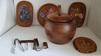 Wide shot showing all items in the lot including the wooden apple-shaped ice bucket, hand-painted plaques, and metal bar tools with wooden handles.