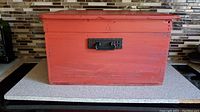 Front view of the rustic red painted wooden box with black metal handle