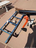 Photo of appliance dolly and Craftsman edger and trimmer on pavement surface