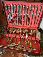 Full view of open anti-tarnish chest containing over 40 pieces of WM Rogers silverplate flatware including knives, forks, spoons and serving utensils.