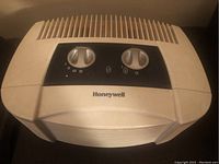 Photo of beige Honeywell air purifier showing the top control panel with two dials and brand logo.