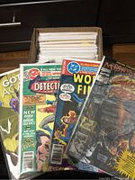 Front row of comics featuring Detective Comics, World's Finest Comics and a Marvel title in protective sleeves