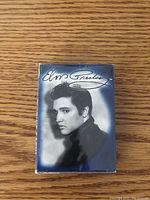 Front of Elvis Presley playing card deck box, showing large portrait of Elvis Presley and signature.