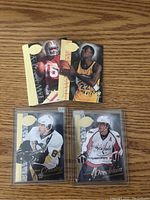 Photo showing multiple sports trading cards including a 49ers NFL card, a Lakers NBA card, Sidney Crosby and Alexander Ovechkin NHL hockey cards.