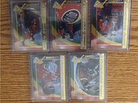 Five metal Jeff Gordon NASCAR trading cards sealed in original plastic sleeves and protected by top loaders, showing front images with race suit and sponsor logos.